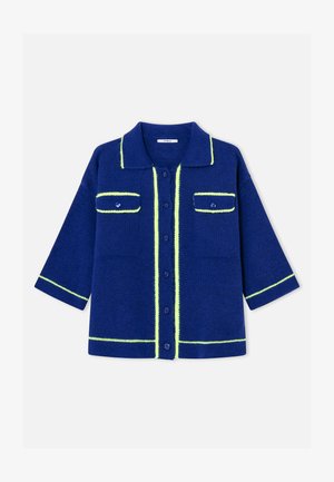 Cárdigan de punto azul marino con ribete amarillo neón, cierre de botones en el frente, dos bolsillos con solapa en el pecho y mangas tres cuartos.