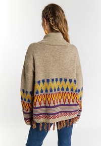 Beige kötött pulóver színes geometrikus mintákkal piros, kék és sárga színben. Magas gallérral és rojtos szegéllyel rendelkezik.