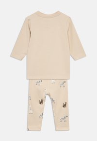 Μπεζ βαμβακερό μακρυμάνικο τοπ και αντίστοιχο κολάν με ζωικά σχέδια σε μαύρο και λευκό, με καμηλοπαρδάλεις και ζέβρες.