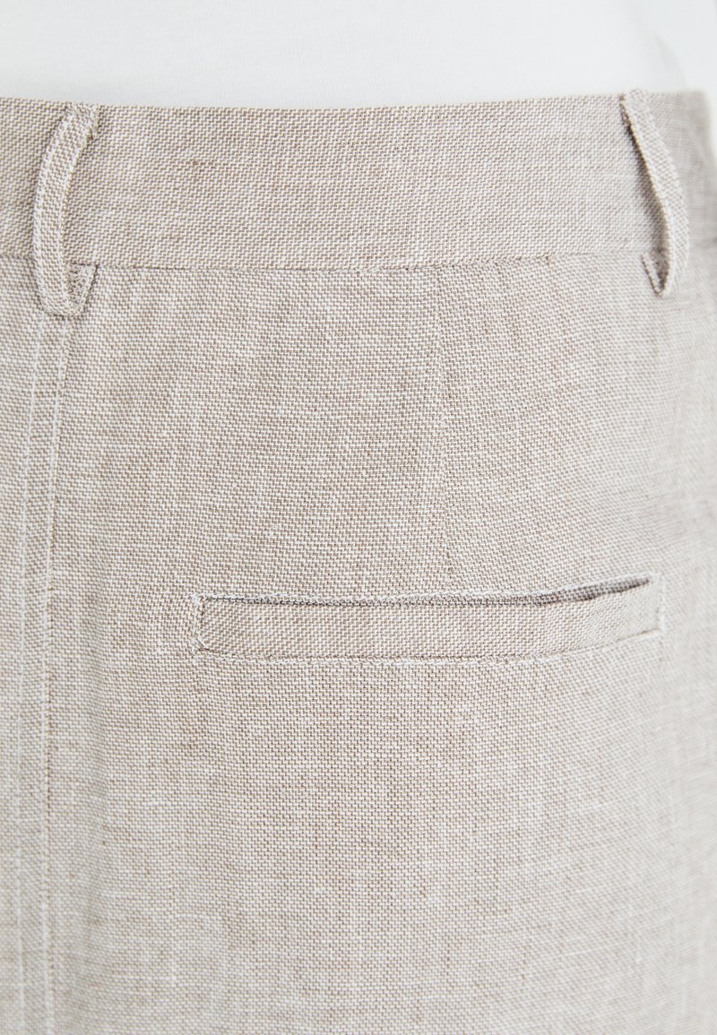 Linnen broeken in lichtbeige met een gestructureerde weving, voorzien van een enkele achterzak en ceintuurlussen. Eenvoudig, op maat gemaakt ontwerp.