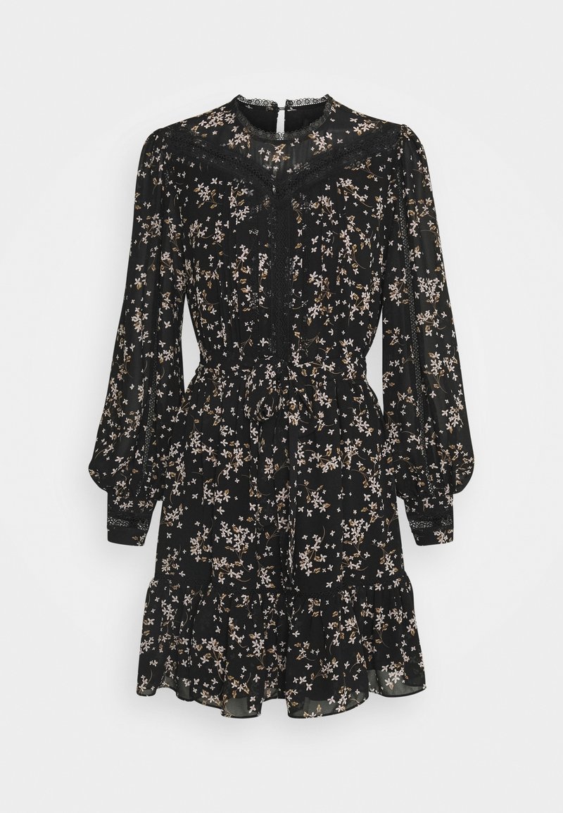 Robe noire à manches longues avec petites fleurs beiges et blanches, détails en dentelle, taille cintrée, ourlet volanté et encolure dos boutonnée.