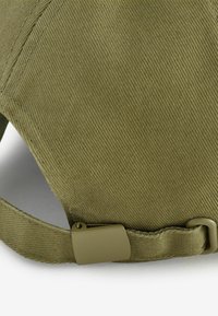 Oliiviroheline nokamüts tekstuurse kangaga, kõverdatud nokk ja taga metallist reguleeritav rihm. Äärtel on tugevdatud õmblused.