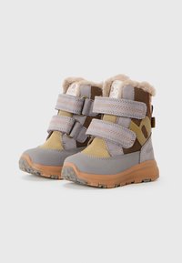 Bottes d'enfant grises et marron avec doublure en fourrure, bandes Velcro, tissu texturé et semelles en caoutchouc. Présente un logo rond et un design bicolore.