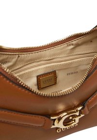 Bolso marrón de piel sintética con herrajes en tono dorado, cierre de cremallera y forro de tela con logotipo de la marca en relieve. Incluye bolsillo interior.