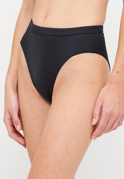 Augstas vidukļa melnie bikiniju apakšdaļa ar gludu, elastīgu audumu. Iespējas bezšuvju, minimālistisks dizains, kas ērti pieguļ gurniem.