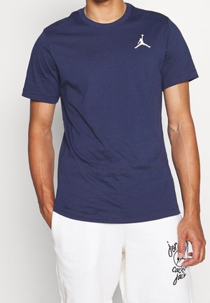 Navy blue short-sleeve T-shirt made of cotton, featuring a white Jumpman logo on the left chest and a classic crew neck design.