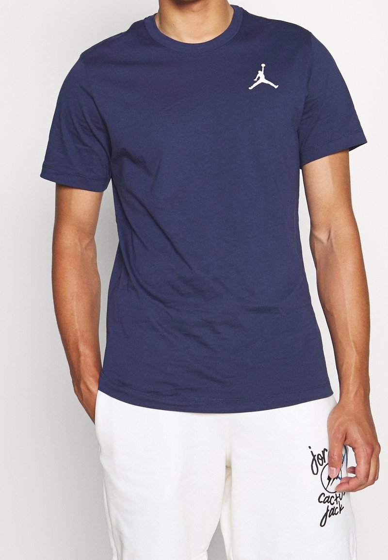 T-shirt à manches courtes bleu marine en coton, avec un logo Jumpman blanc sur la poitrine gauche et un col rond classique.