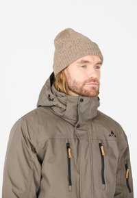 Bruine waterdichte jas met ritszakken, verstelbare capuchon en warme tan gebreide muts. Heeft een subtiel patroon en contrasterende hardware accenten.