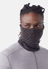 Gaiter de cou à motifs multiples présentant un mélange de nuances de bleu, orange et noir. Tissu doux avec un design tubulaire extensible.