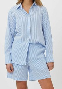 Chemise à rayures bleues et blanches à boutons, manches longues, assortie à un short rayé, fabriquée en tissu léger.