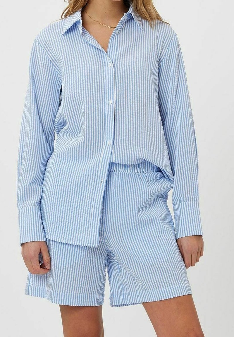 Chemise à rayures bleues et blanches à boutons, manches longues, assortie à un short rayé, fabriquée en tissu léger.