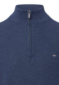 Dunkelblauer Strickpullover mit einem Viertelreißverschluss. Hat einen strukturierten Stoff und ein kleines, silbernes Logo, das auf der linken Brust gestickt ist.