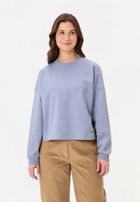 Lichtblauwe cropped sweatshirts met een ronde hals, lange mouwen en geribbelde manchetten, gecombineerd met lichtbruine corduroy broek.