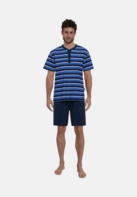 Gestreiftes kurzärmeliges Hemd in Blau und Weiß mit einer Knopfleiste mit drei Knöpfen, kombiniert mit navyfarbenen Shorts. Aus Baumwollmaterial, lockere Passform.