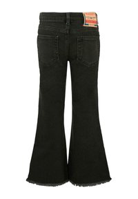 Jean évasé noir avec ourlet brut, texture délavée et deux poches arrière. Inclut une étiquette de marque sur la taille.