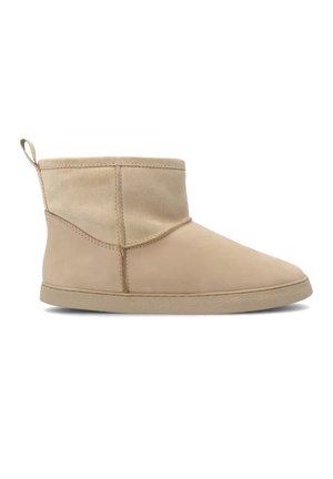 Bota beige hasta el tobillo con suela plana, parte superior de ante suave y tira en la parte trasera, adecuada para uso casual.