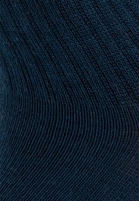 Granatowa dziana tkanina z diagonalną fakturą żebrową, z cienkimi, równymi ściegami i miękkim, lekko elastycznym wyglądem.