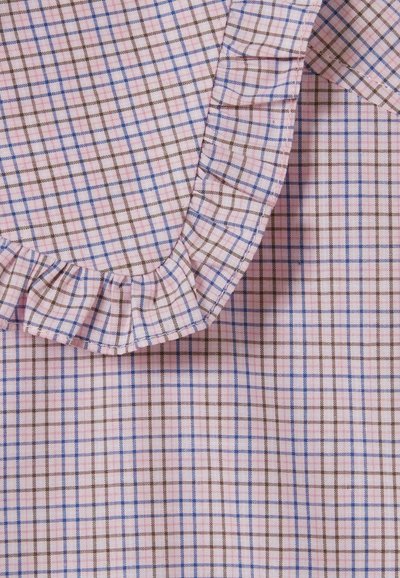Tela de color rosa claro con un patrón de cuadros en azul y marrón. Presenta un borde con volantes alrededor del cuello, añadiendo textura y detalle.