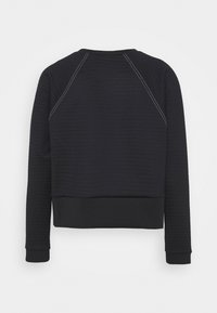 Sweat-shirt noir à manches longues avec des bandes perforées horizontales et des surpiqûres blanches contrastantes sur les coutures des épaules, vu de dos.