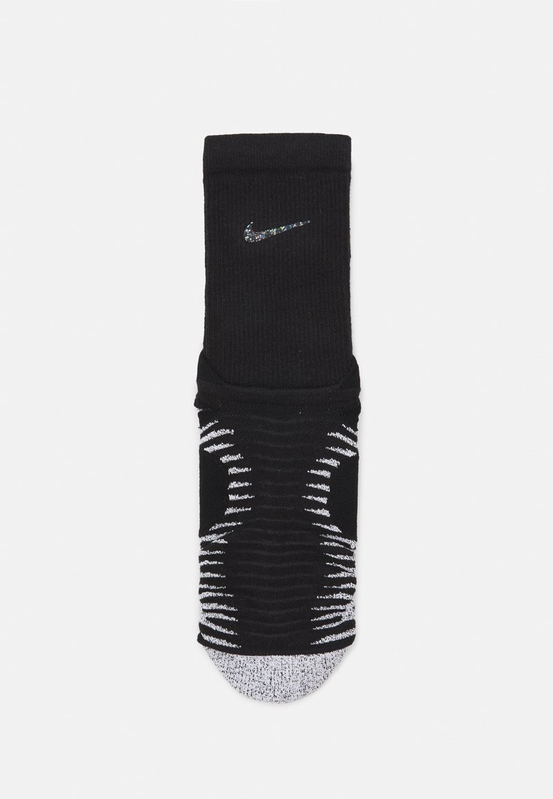 Černá ponožka Nike s žebrovanou strukturou, na svršku s bílým pruhovaným vzorem a stříbrným logem na lemu. Měkká tkanina s vyztuženou špičkou.