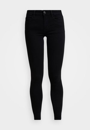 Black high-waisted skinny jeans made of denim. Features a traditional button and zipper closure, with front pockets and a sleek fit.