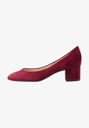Escarpin en suede bordeaux avec un bout arrondi, un petit talon bloc, et un intérieur lisse. Présente un design sans couture sans matériel visible.