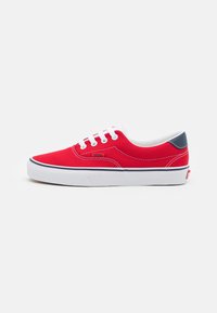 Sneaker in tela rossa con lacci bianchi e suola bianca. Caratterizzato da un dettaglio blu navy sul tallone e un logo sul lato.