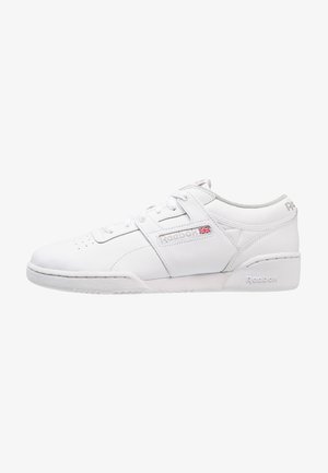 Białe niskie buty sportowe Reebok z sznurowaniem, skórzaną cholewką, logo Reebok i flagą Wielkiej Brytanii z boku oraz wyściełanym kołnierzem dla wsparcia kostki.