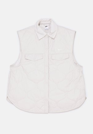 Κουβερτοφόρος αμάνικο γιλέκο σε ανοιχτό μπεζ με κουμπιά μπροστά, δύο τσέπες στο στήθος και λογότυπο της Nike στη αριστερή πλευρά. Απαλή υφή.