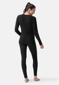 Svart långärmad topp och leggings i mjuk, stretchig kvalitet, med slim fit och raglanärmar, med minimala sömmar och utan mönster.