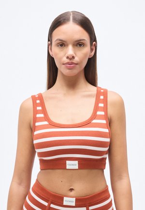 Κοντό τοπ με κόκκινες και λευκές ρίγες κατασκευασμένο από ριμπ ύφασμα, με φαρδύ λαιμόκοψη και ετικέτα με την επιγραφή "CLOSED" στο τελείωμα.