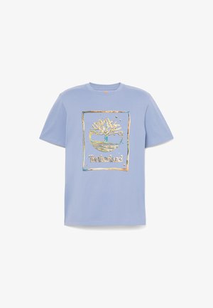 Maglietta di cotone azzurro chiaro con grafica dorata e verde di un albero all'interno di una cornice rettangolare con la scritta "Timberland" sotto.