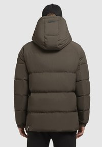 Olive green puffer jacket with a hood, featuring a quilted design, elastic cuffs, and a brand tag on the back. Soft, textured fabric.