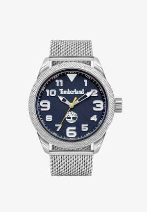 Srebrny zegarek na siateczkowym pasku z granatową teksturowaną tarczą, białymi cyframi i żółtą wskazówką sekundową. Na tarczy znajduje się logo Timberland.