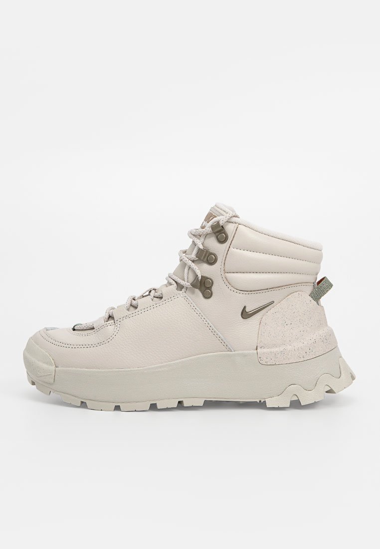 Botas de senderismo beige con un upper texturizado, puntera reforzada, cuello acolchado y acentos en bucle. Presentan una suela gruesa y robusta para tracción.