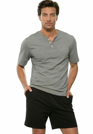Graues Kurzarm-Henley-Shirt mit einer Dreiknopfleiste und schwarzen Shorts. Das Shirt hat einen strukturierten Stoff, und die Shorts besitzen Seitentaschen.