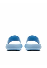 Heledad sinise tooni avatud varvaga sandaalid tekstuurse pinnaga, kumerate külgedega ja tasaste talladega. Minimalistlik disain, valmistatud paindlikust ja vastupidavast materjalist.