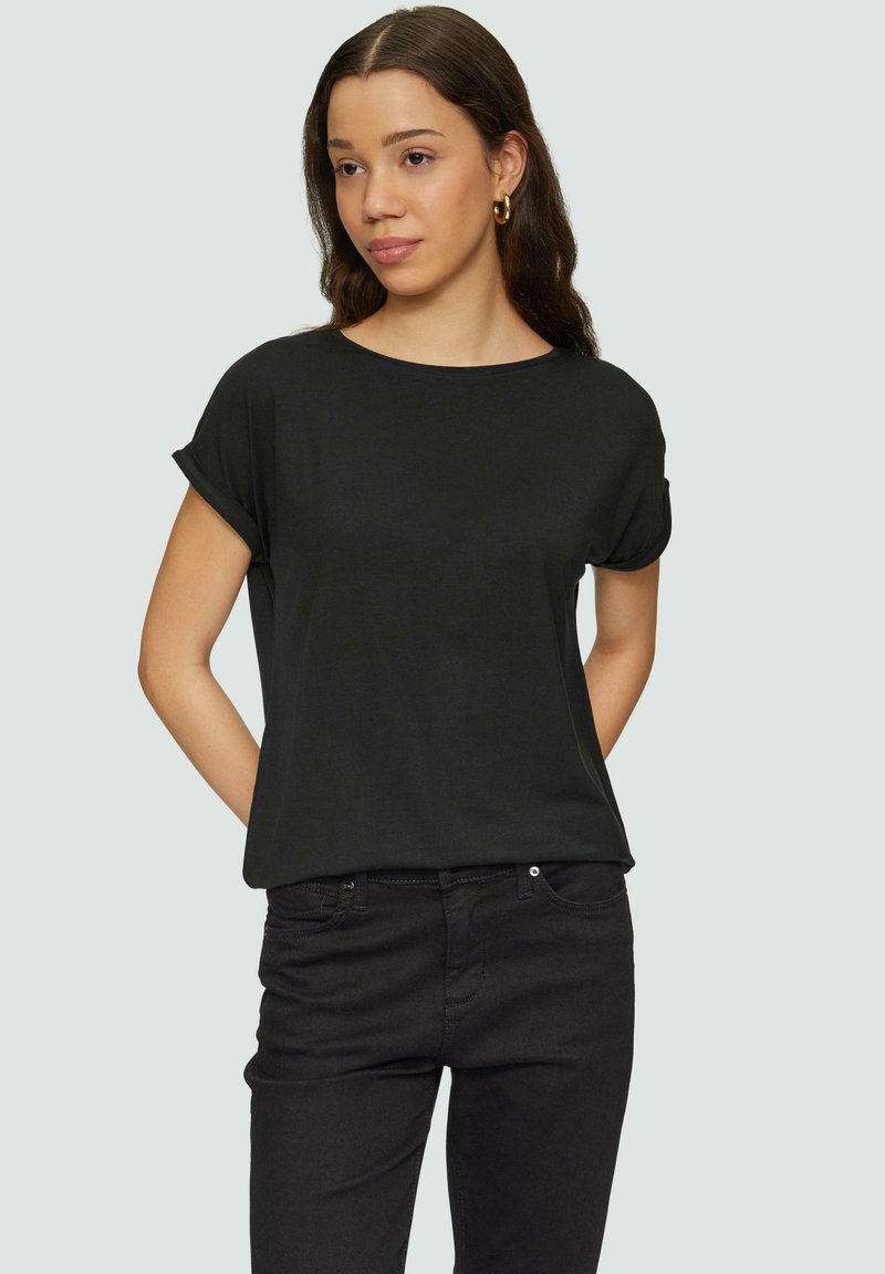 Zwarte T-shirt met korte mouwen, gemaakt van zachte stof, met een relaxed fit en een ronde halslijn, gecombineerd met donkere jeans.