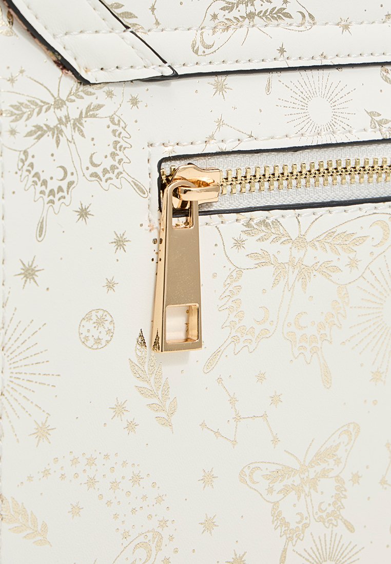 Sac blanc avec une fermeture éclair dorée et des motifs de papillons, d'étoiles et de feuilles en doré sur la surface.