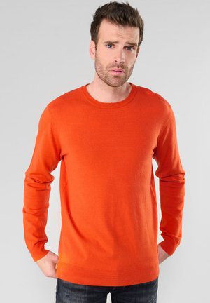 Pull orange en tricot doux, avec un col rond, des manches longues et des bords côtelés au niveau des poignets et de l'ourlet. Design simple sans motifs.