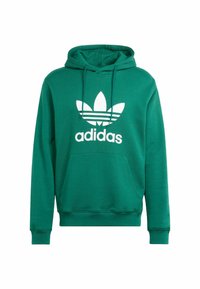 Zelená bavlnená mikina s klokankovým vreckom, obsahuje logo Adidas v bielej farbe a klasický dizajn s tromi pruhmi. Kapucňa s nastaviteľným šnúrkovým uzáverom.