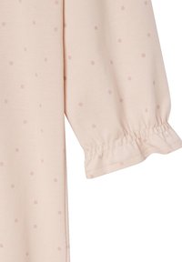 Helle rosa Stoff mit glatter Textur, versehen mit kleinen, gepunkteten Mustern in einer dunkleren Nuance. Elastischer Bund am Ärmel.