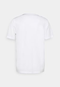 Vit kortärmad T-shirt i slät tyg. Har rund halsringning och rak fåll. Inga synliga mönster eller dekorationer.