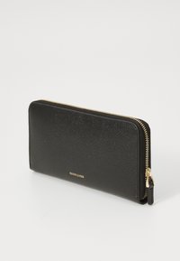 Portefeuille en cuir noir avec une surface texturée, fermeture éclair dorée et détail de logo. Forme rectangulaire avec un profil mince.