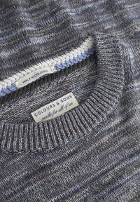 Grauer und blauer gestrickter Pullover mit einem gerippten Rundhalsausschnitt, strukturiertem Muster und Etiketten mit den Aufschriften "WALK IN COLOURS" und "COLOURS & SONS."