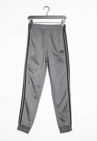 Grijze sportbroek van gladde stof, met een elastische tailleband, zwarte zijstrips en een Adidas-logo op het linkerbeen.