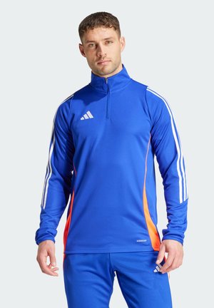 Blauw sportief shirt met lange mouwen en hoge kraag, witte strepen op de mouwen en oranje zijkanten. Gemaakt van ademend materiaal.