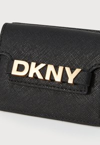Crni teksturirani novčanik od sintetičkog materijala s zlatnim "DKNY" logotipom i kompaktnim pravokutnim dizajnom.