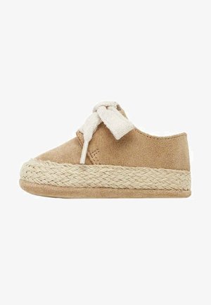 Chaussure enfant en daim beige à enfiler avec une semelle épaisse tissée et un grand nœud en tissu crème sur le dessus, vue de profil sur fond blanc.
