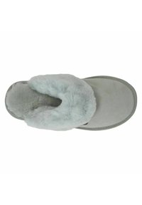 Grijze suède pantoffel met lichtgrijze faux bontvoering, ronde neus en een gestructureerde zool. Heeft een gestikt randje en een gezellige uitstraling.